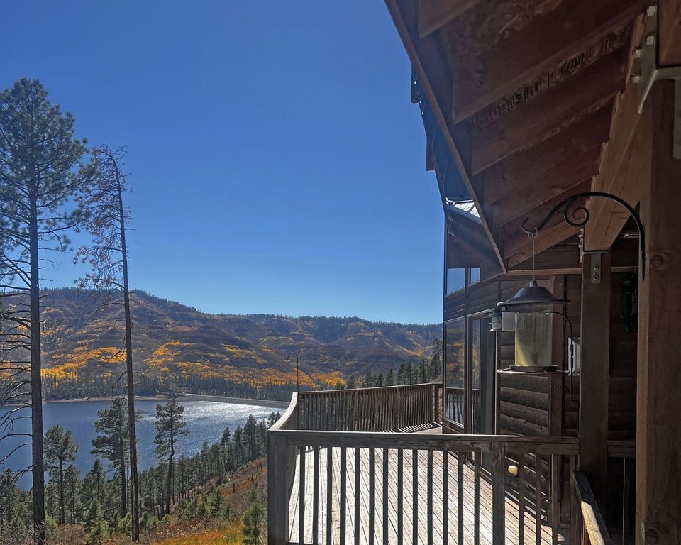A log-home deck looking down over Vallecito Lake and fall aspens