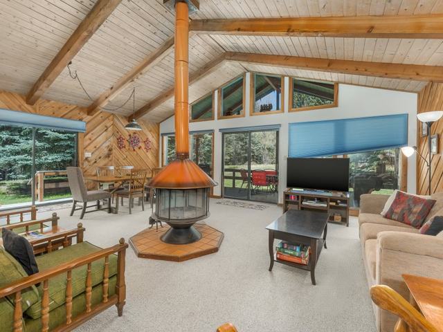 Creekside home's open living room with a round hanging fireplace