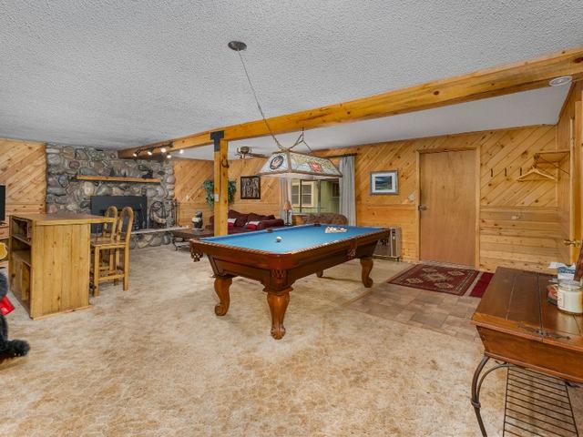 Meadow View's great room with a pool table and stone fireplace