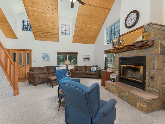 River Song's two-story living room with a stone fireplace