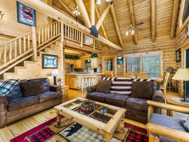 Top of the Pines log-home living room with a log staircase